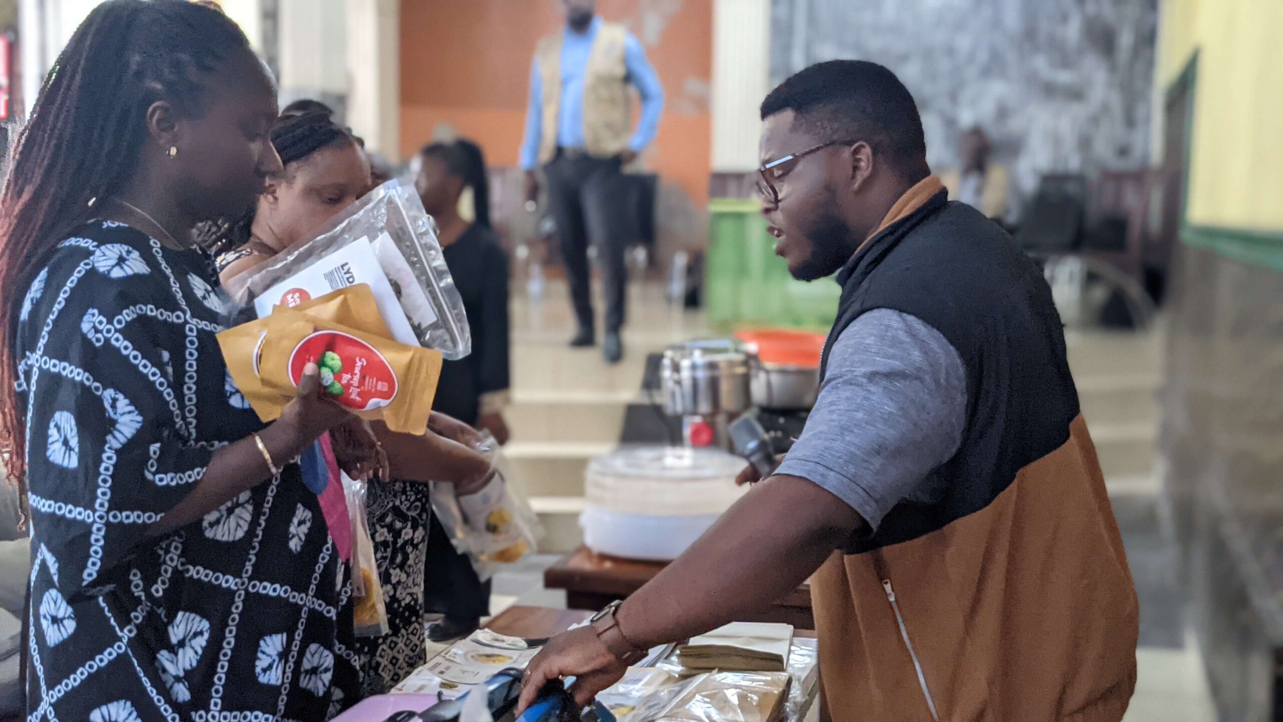 Visitors look at Mumita products at an exhibition stand