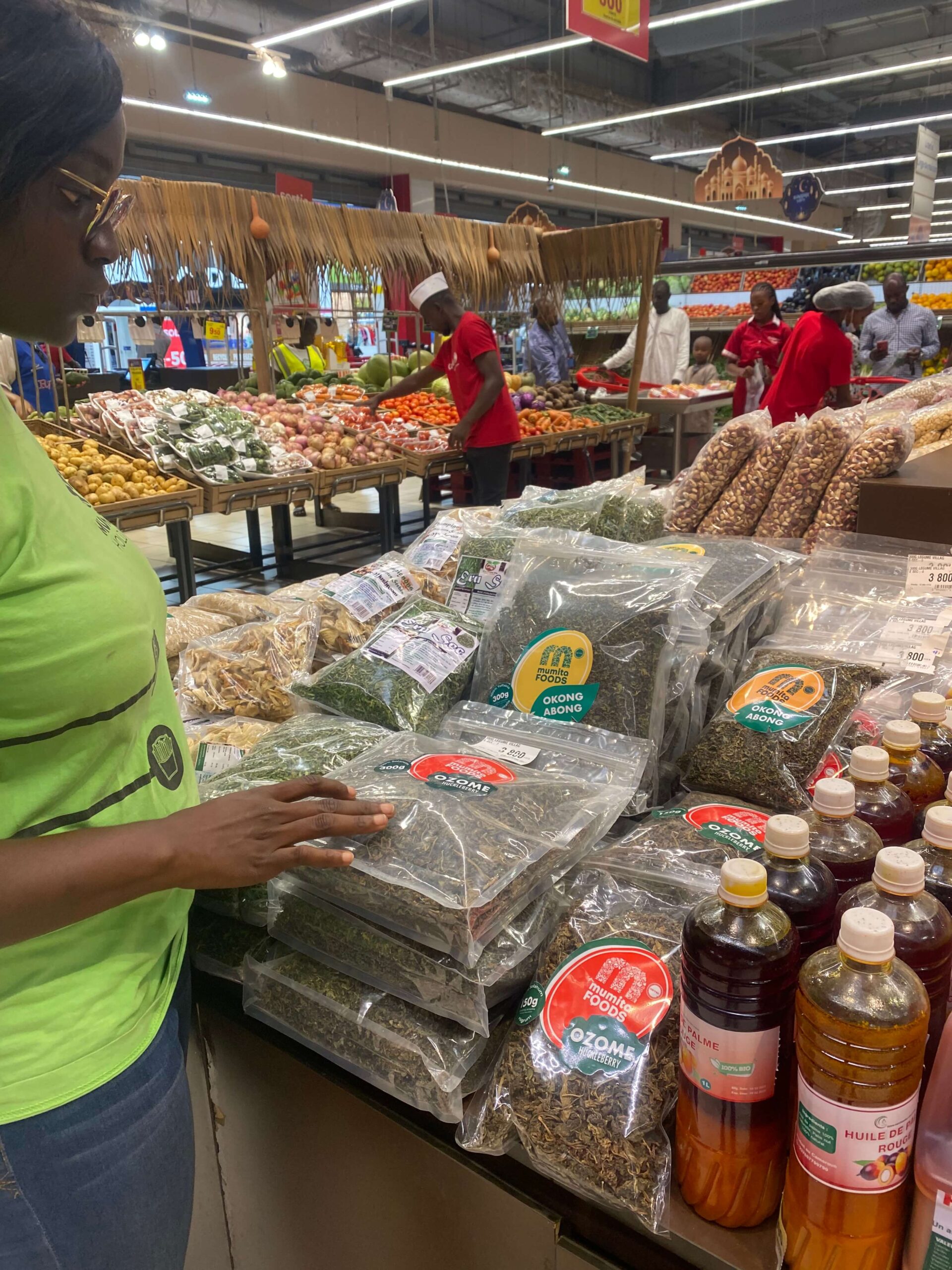 Mumita Foods vegetable packs on a market display, shoppers behind