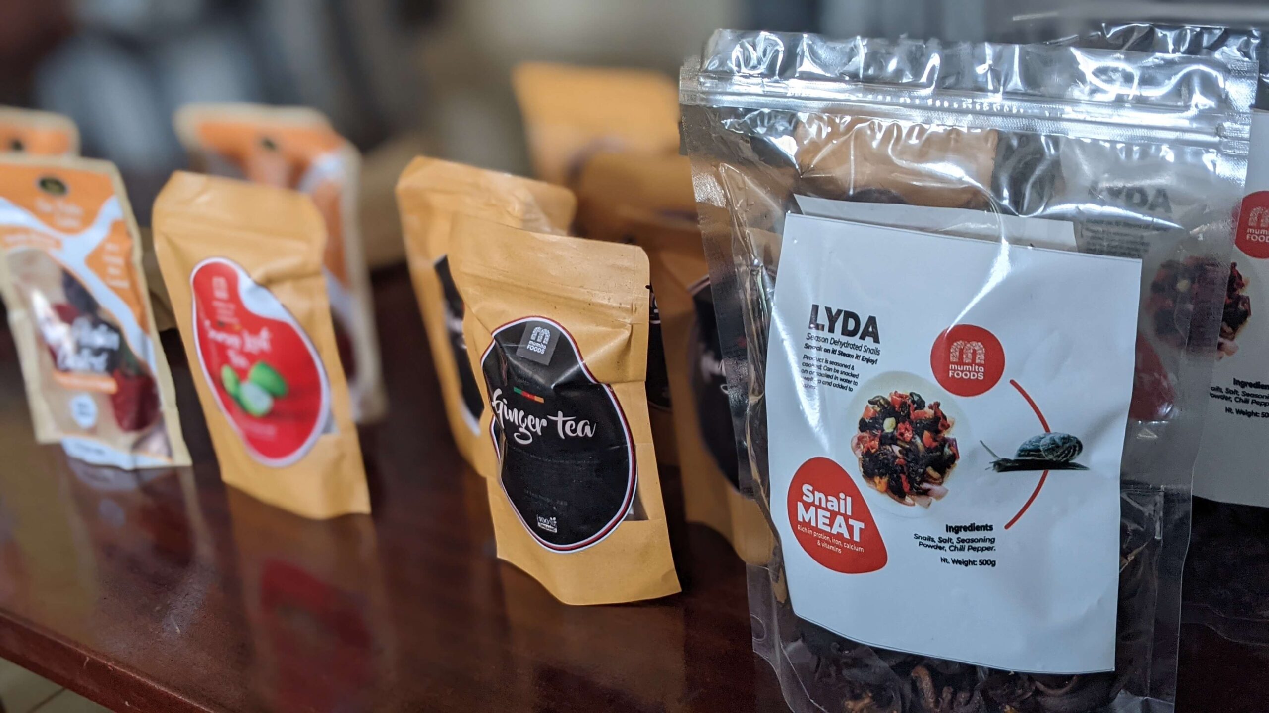 Mumita Foods pouches on a table: ginger tea, other teas and a LYDA snail meat pack