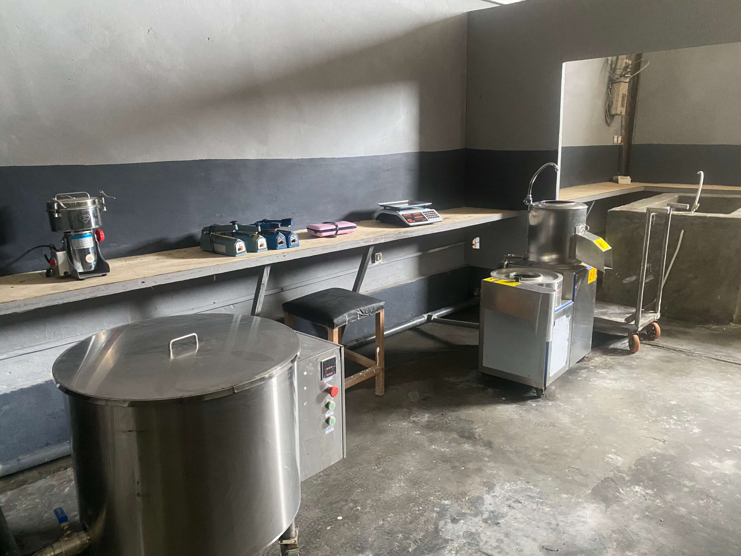 The processing room with a stainless cooking vat, a mill and benches