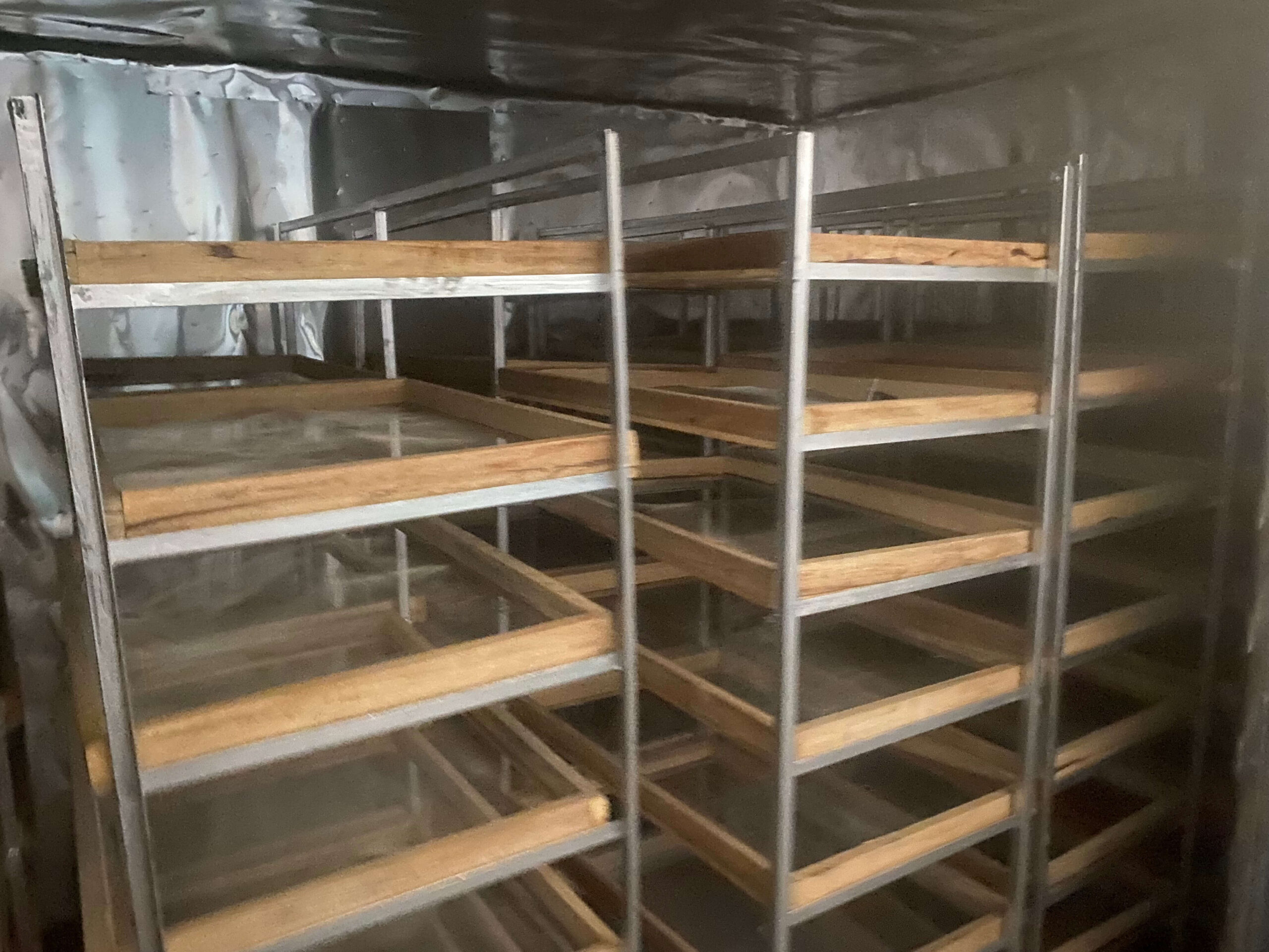 Stainless racks holding wooden-framed drying trays