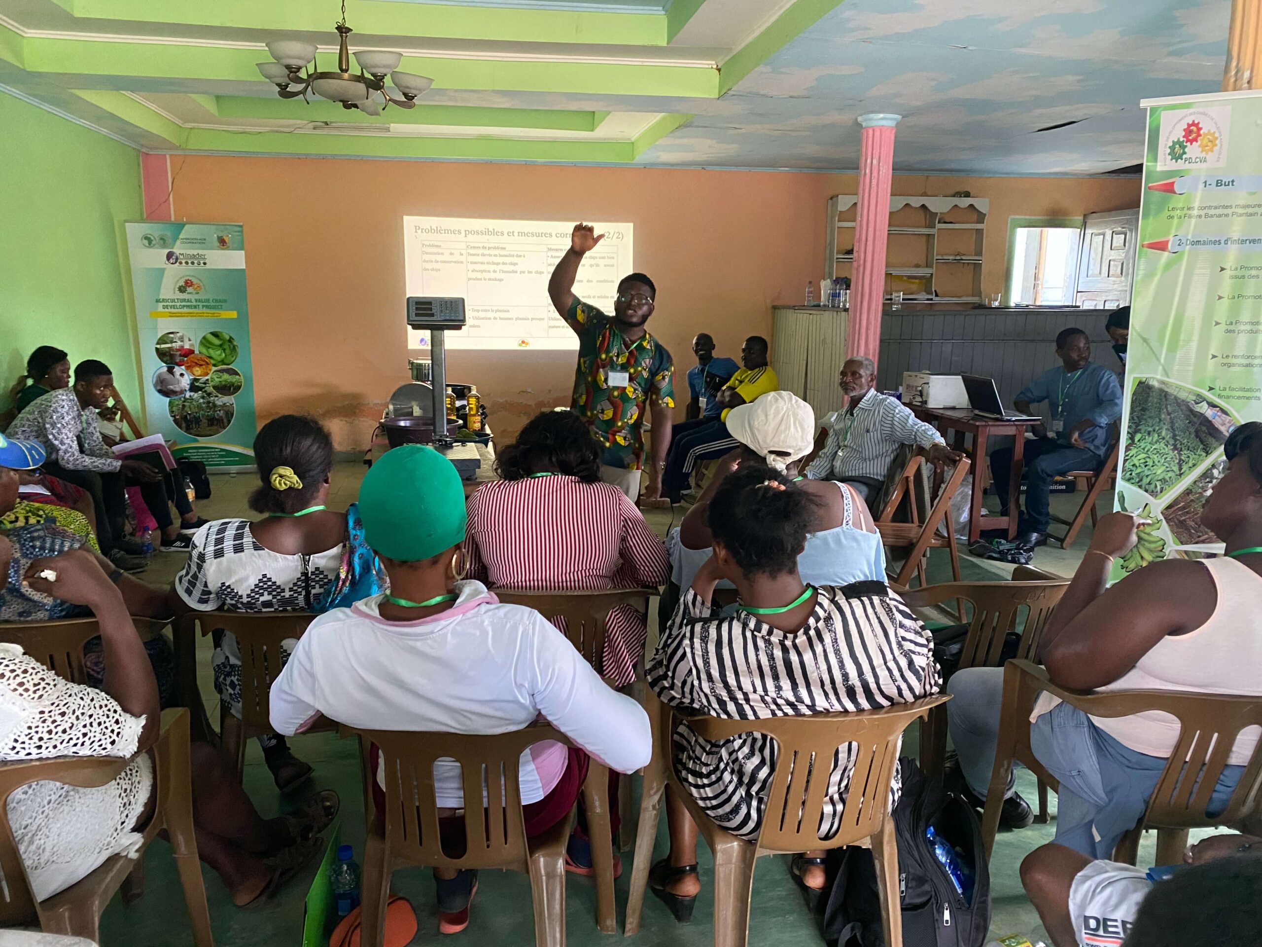 A trainer speaks to a room of seated participants at a training session