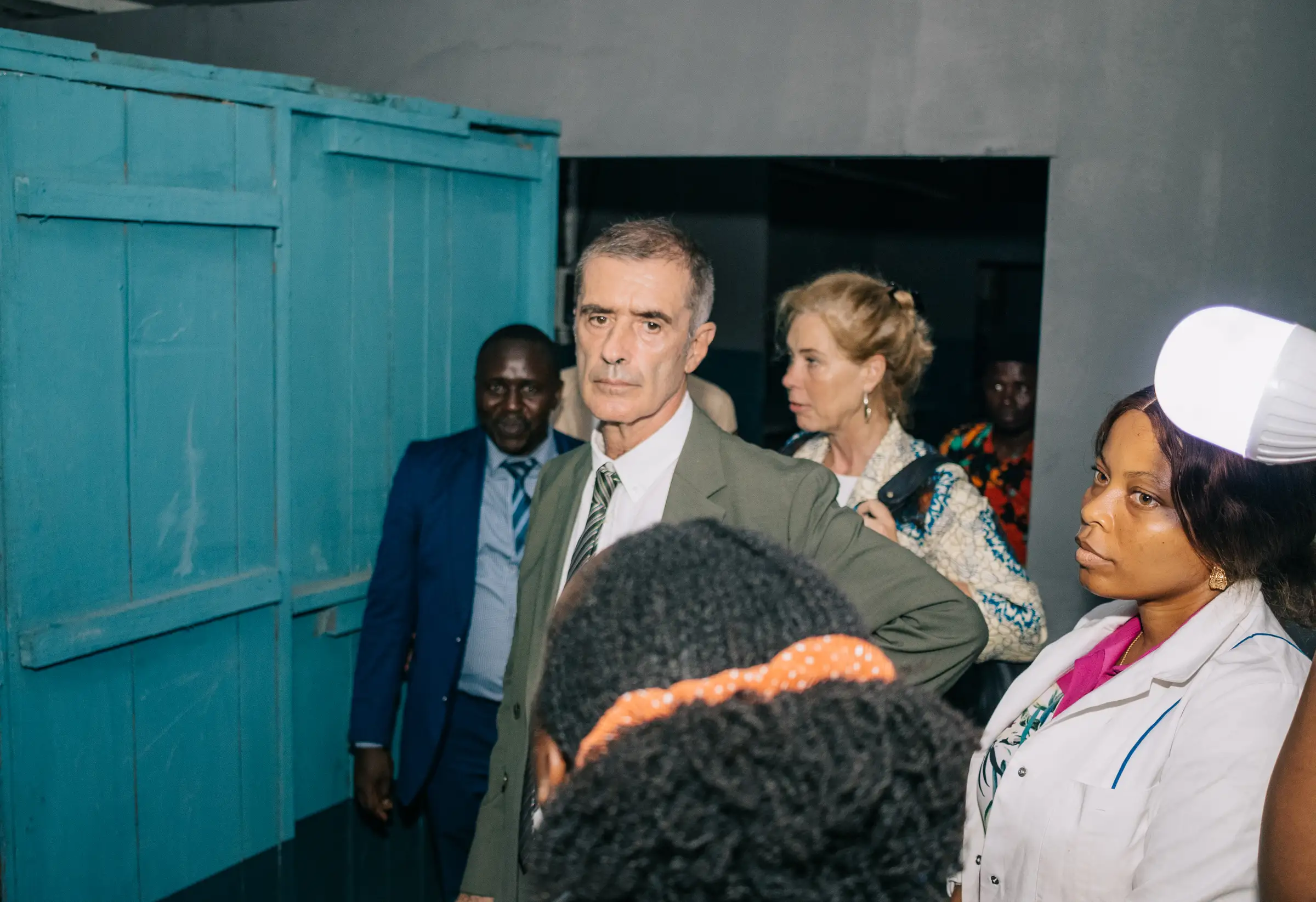 Visitors from the French Embassy consular office and Mumita staff beside the door of a storage room