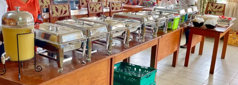 A Praïs buffet line of chafing dishes and a juice dispenser