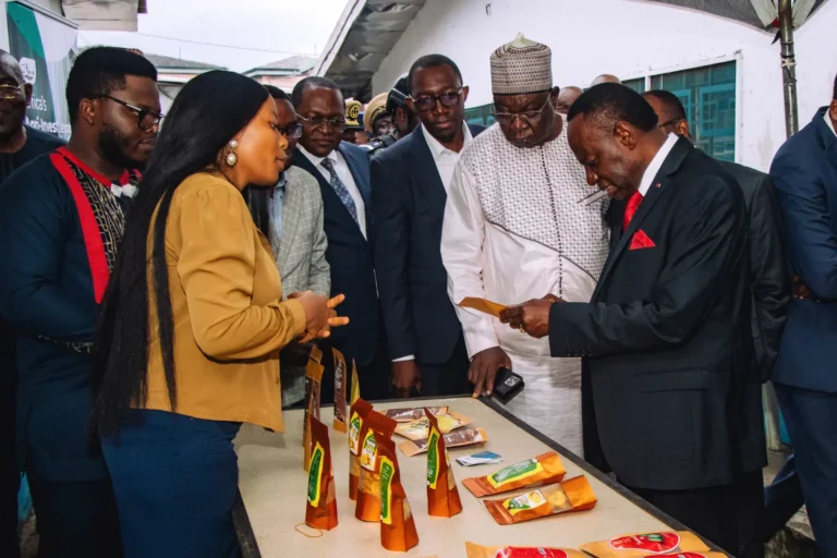 An official examines a Mumita product at the display table