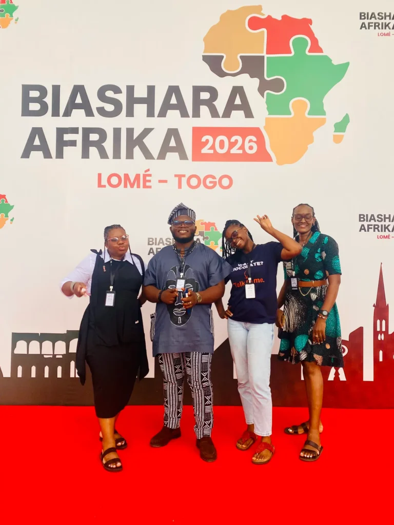 Four delegates in front of the Biashara Afrika 2026 backdrop in Lomé