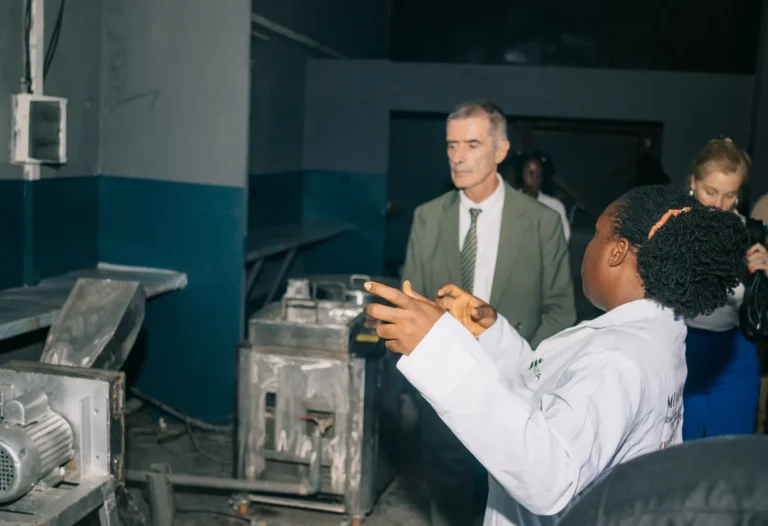 A staff member explains the processing machines to the French Embassy consular delegation