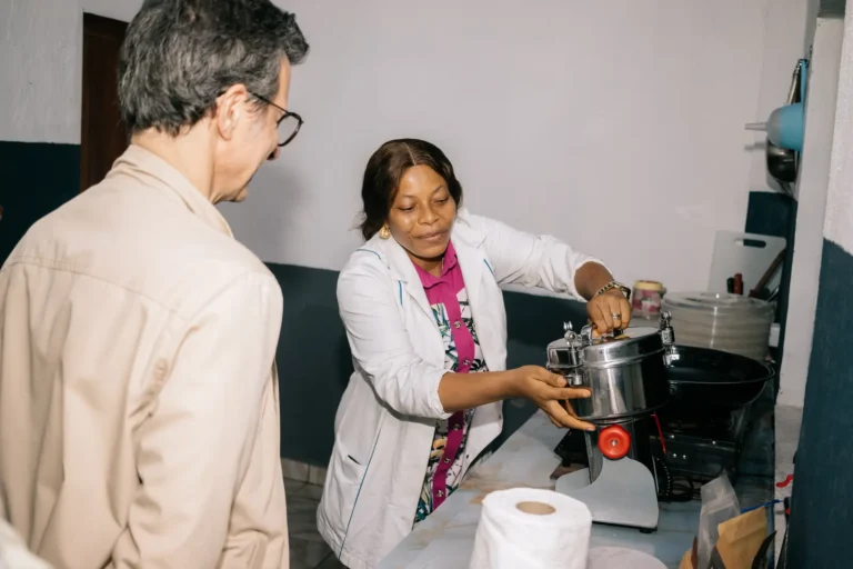 A staff member demonstrates a grinder to the French Embassy consular delegation