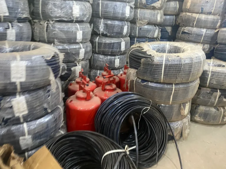 Coils of irrigation pipe and pressure tanks stacked in the warehouse