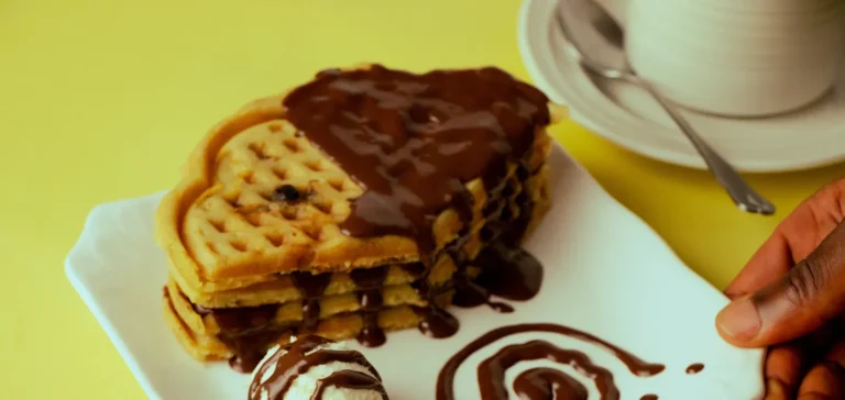 A waffle stack with chocolate sauce and ice cream