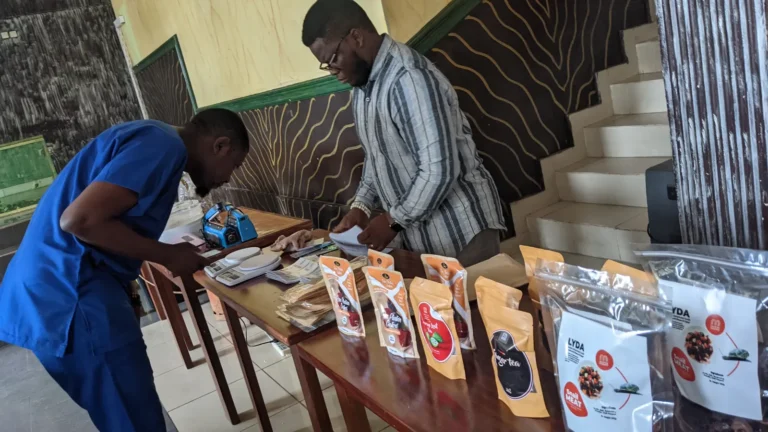 Staff arrange a table of Mumita pouches at a youth workshop