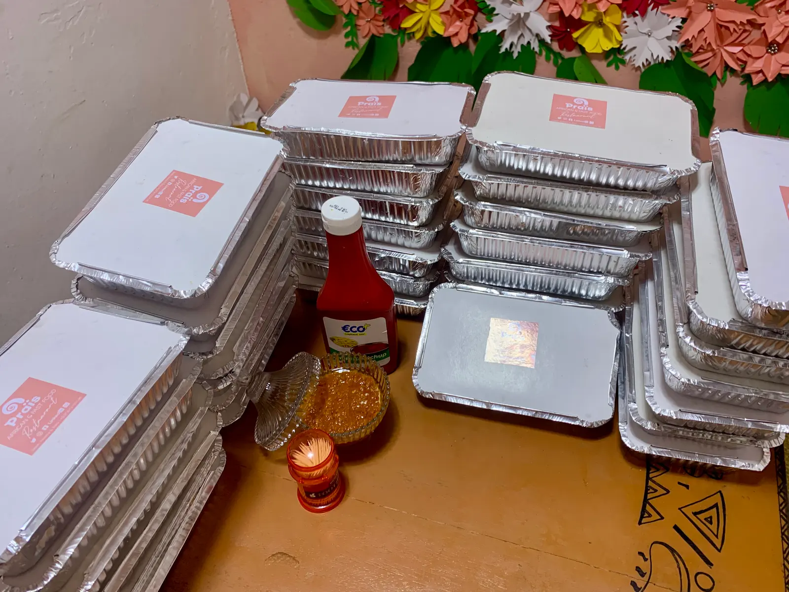 Stacks of foil takeaway trays with red-labelled lids, ready for an event